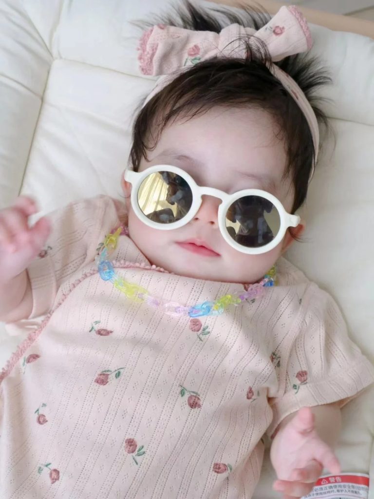 3-month-old baby wearing UV protection sunglasses outdoors