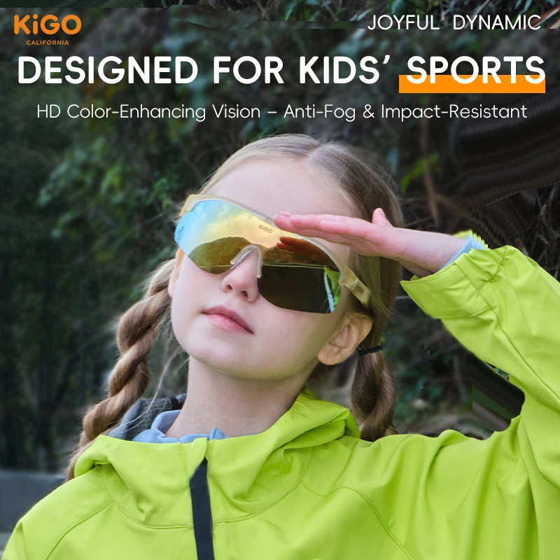 A girl in a bright green jacket wearing KIGO California sports sunglasses. Text reads "DESIGNED FOR KIDS’ SPORTS", "HD Color-Enhancing Vision – Anti-Fog & Impact-Resistant", with "JOYFUL DYNAMIC" and the brand logo in the corners, set against a green, leafy background.