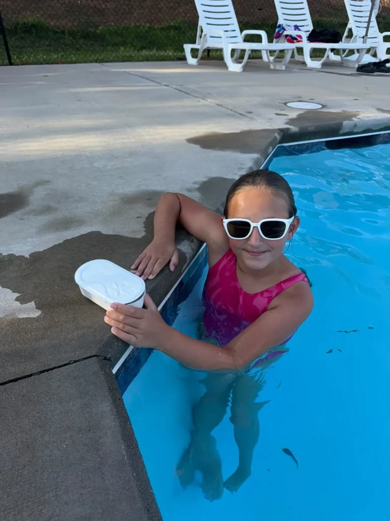 A girl wearing KiGO California 12+ years white sunglasses swimming in the pool.