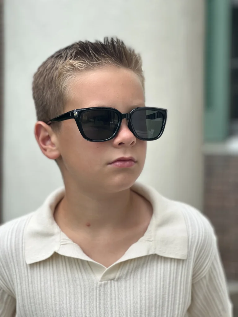 A handsome boy wearing KiGO California 12+ years Black sunglasses for outgoing.
