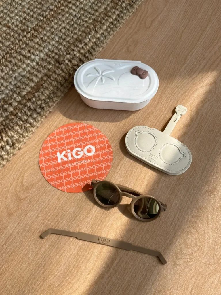 KiGO California best sunglasses for kids with sensitive eyes for 0-2 years old or 2-5 years product gift package. It includes a pair of glasses, a glasses cloth, a glasses strap, a glasses bag for easy storage and a box that can hold the above items.